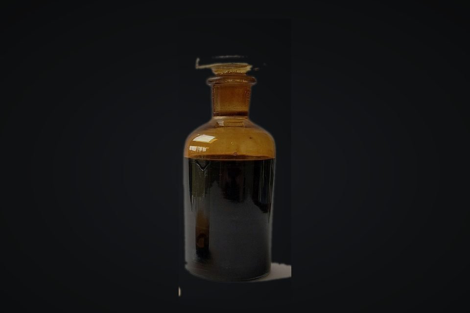 Sample of crude oil in a dark amber glass bottle
