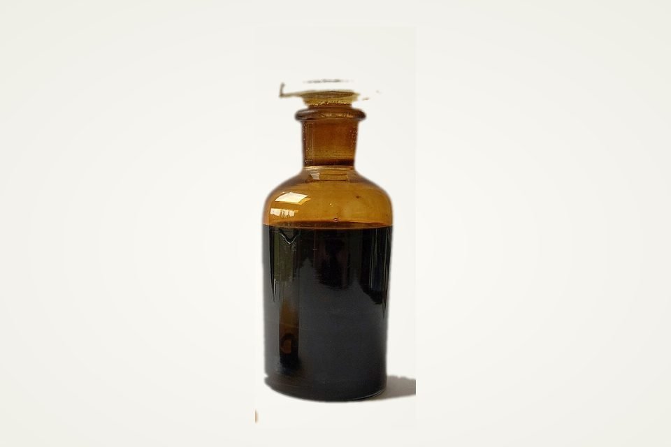 Sample of crude oil in a dark amber glass bottle